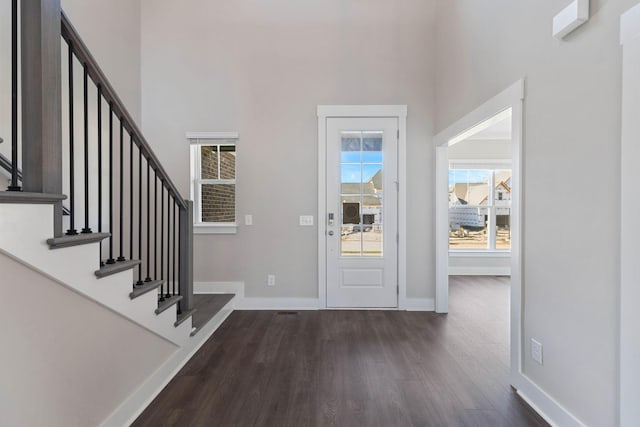 entryway with dark wood-type flooring and a high ceiling