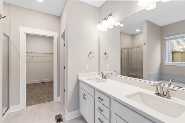 bathroom with tile patterned flooring, vanity, and a shower with shower door