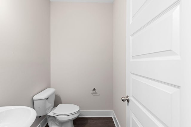 bathroom with hardwood / wood-style flooring and toilet