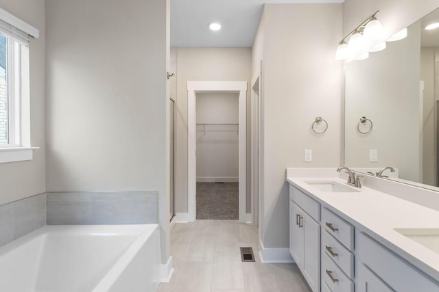 bathroom with vanity and a tub to relax in