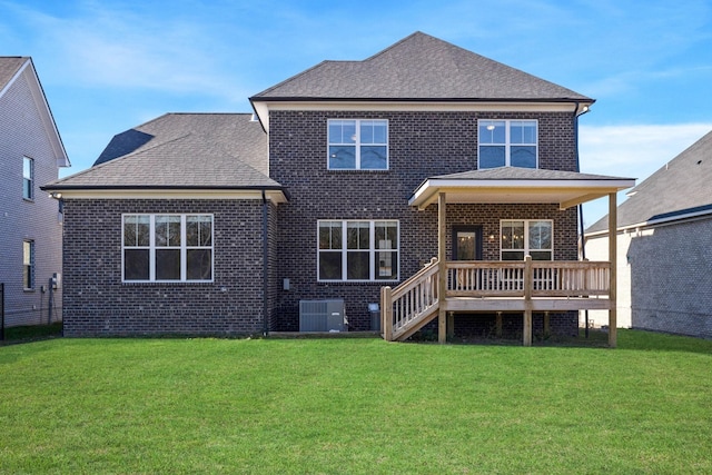 back of property with a wooden deck, a yard, and central AC unit