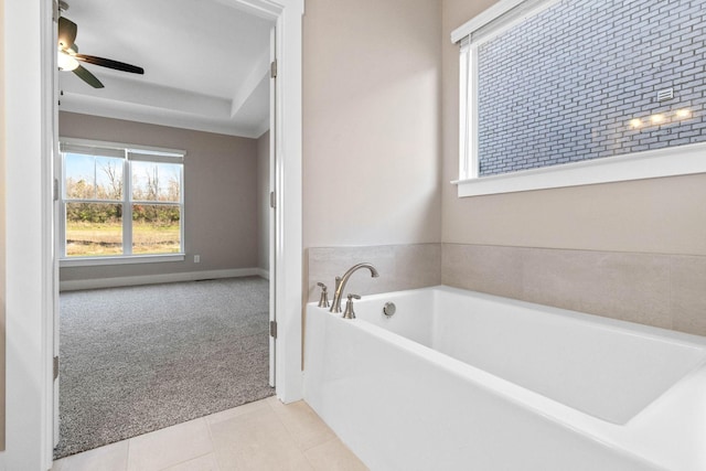 bathroom featuring ceiling fan, tile patterned floors, and a bathtub