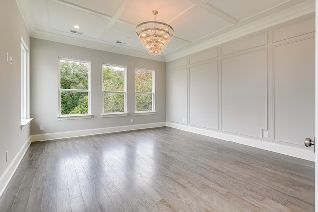 unfurnished room featuring coffered ceiling, ornamental molding, a notable chandelier, beam ceiling, and hardwood / wood-style floors