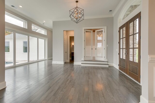 entrance foyer with french doors, ornamental molding, dark hardwood / wood-style flooring, and a notable chandelier