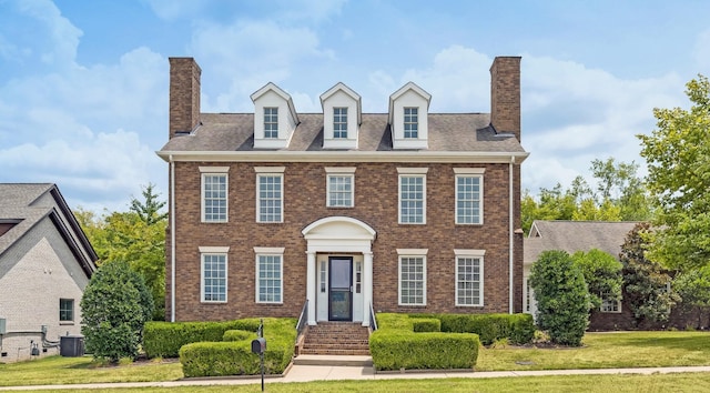 colonial-style house with central AC unit and a front yard