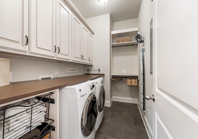 clothes washing area featuring cabinets, washing machine and dryer, and dark tile patterned flooring