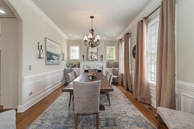 dining space with crown molding, a chandelier, and hardwood / wood-style floors