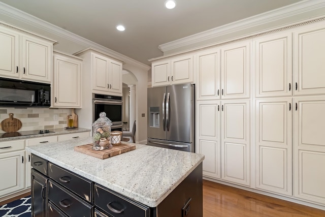 kitchen featuring a kitchen island, tasteful backsplash, wood-type flooring, ornamental molding, and black appliances