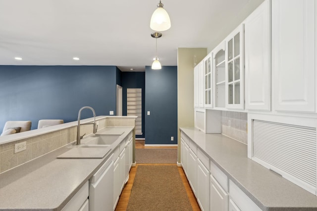 kitchen with sink, white cabinetry, decorative light fixtures, dishwasher, and decorative backsplash