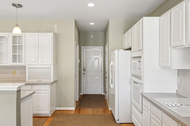 kitchen with tasteful backsplash, white cabinets, white appliances, and decorative light fixtures