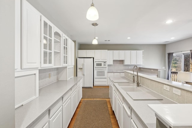 kitchen with white cabinetry, white appliances, sink, and hanging light fixtures