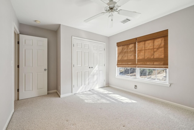 unfurnished bedroom with light carpet, ceiling fan, and a closet