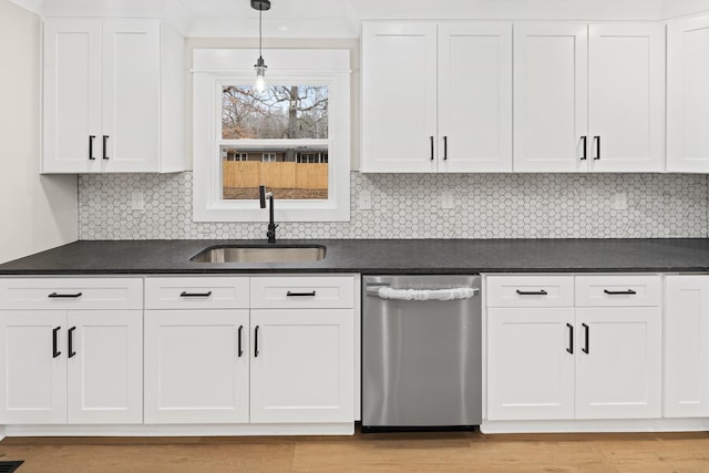 kitchen with pendant lighting, sink, white cabinets, decorative backsplash, and stainless steel dishwasher