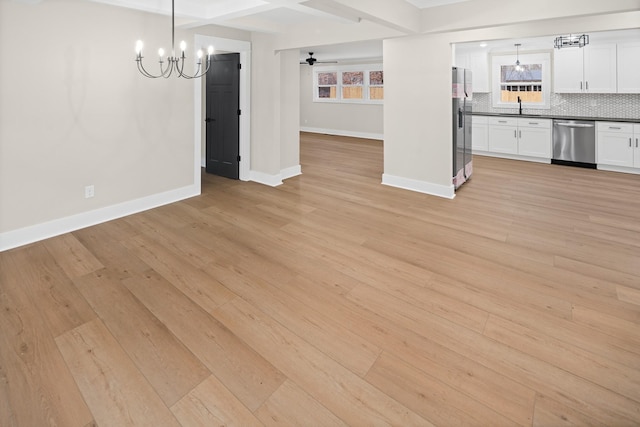 interior space with ceiling fan with notable chandelier, sink, light hardwood / wood-style floors, and beamed ceiling