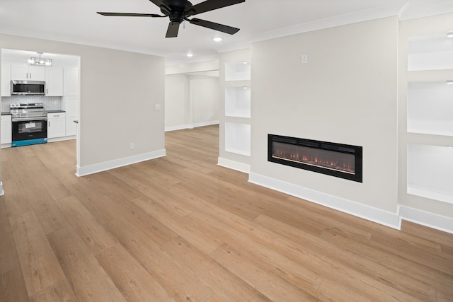 unfurnished living room with ceiling fan with notable chandelier, ornamental molding, and light wood-type flooring