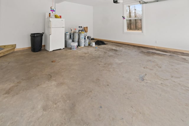 garage with a garage door opener and white fridge