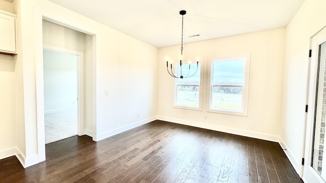 unfurnished dining area with a notable chandelier and dark hardwood / wood-style floors