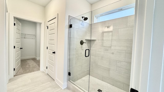 bathroom featuring a shower with door