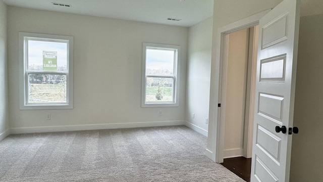 spare room with dark colored carpet