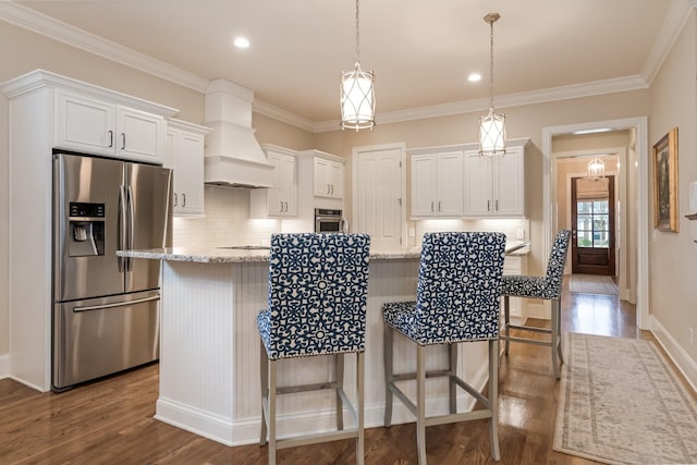 kitchen with a kitchen island, white cabinetry, appliances with stainless steel finishes, and premium range hood