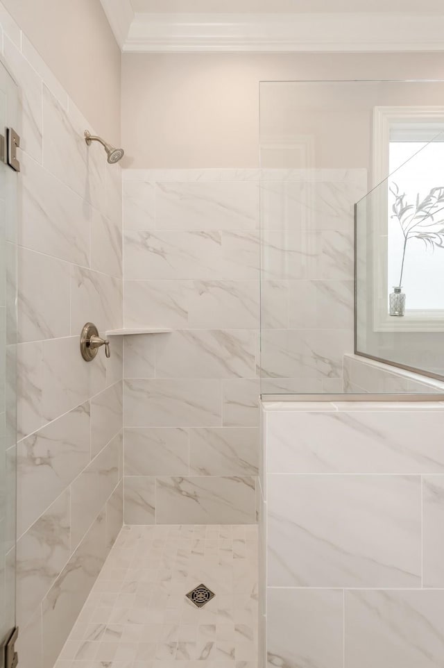 bathroom featuring crown molding and a tile shower