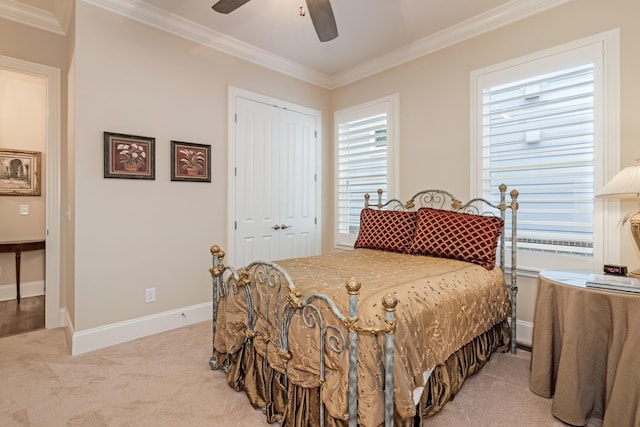 carpeted bedroom featuring crown molding, a closet, and ceiling fan