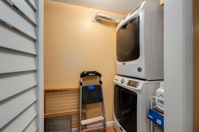 laundry room with stacked washer and clothes dryer, hardwood / wood-style floors, and a textured ceiling