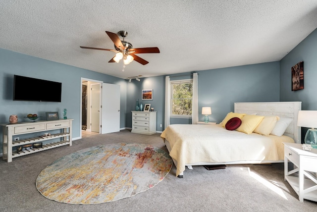 bedroom with ceiling fan, carpet flooring, and a textured ceiling