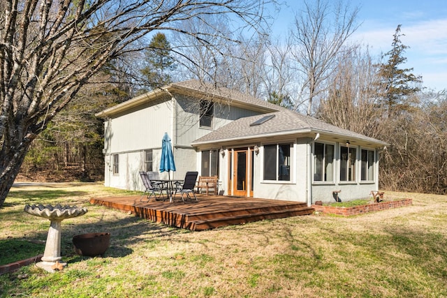 rear view of property featuring a deck and a lawn