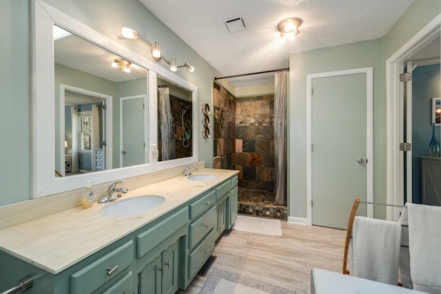 bathroom with wood-type flooring, vanity, a textured ceiling, and a shower with curtain