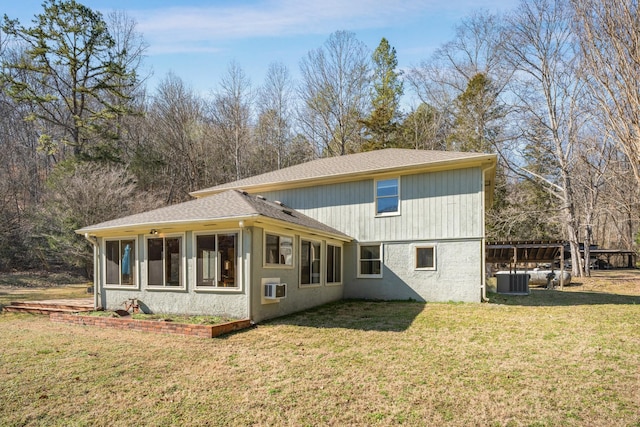 back of property featuring a yard, a wall mounted air conditioner, and central air condition unit