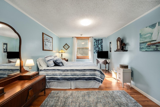 bedroom with hardwood / wood-style floors, crown molding, and a textured ceiling