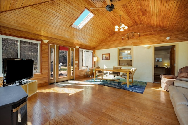 home office with wood ceiling, light hardwood / wood-style flooring, a skylight, wooden walls, and ceiling fan with notable chandelier