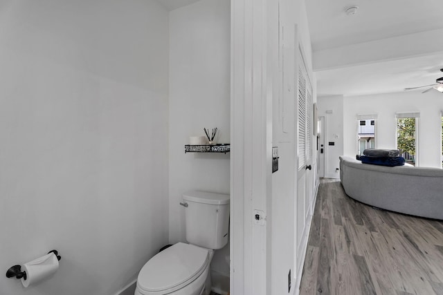 bathroom with hardwood / wood-style floors, toilet, and ceiling fan