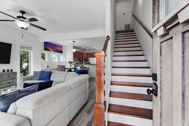 living room featuring dark wood-type flooring and ceiling fan