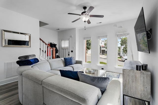 living room featuring ceiling fan and dark hardwood / wood-style flooring