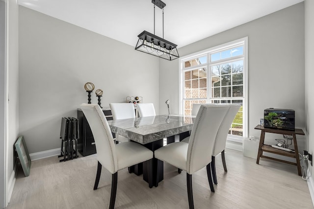 dining room with baseboards and light wood finished floors