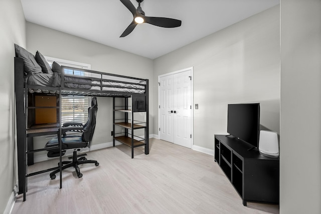 bedroom with ceiling fan, wood finished floors, and baseboards