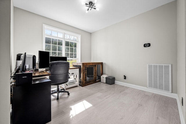 office space with wood finished floors, visible vents, and baseboards