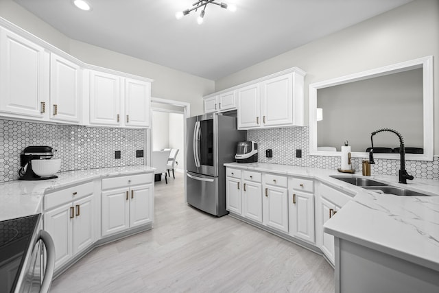 kitchen featuring stove, smart refrigerator, a sink, and white cabinets