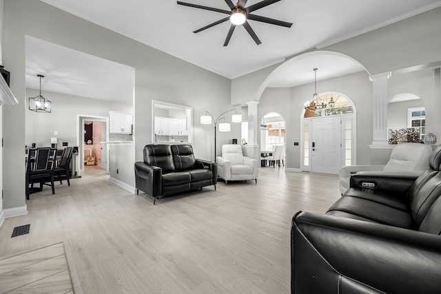 living area featuring visible vents, light wood finished floors, decorative columns, and baseboards