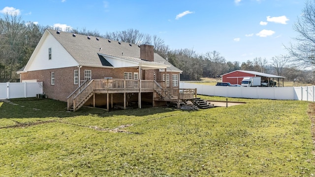 back of house with a fenced backyard, stairs, a lawn, a wooden deck, and a chimney