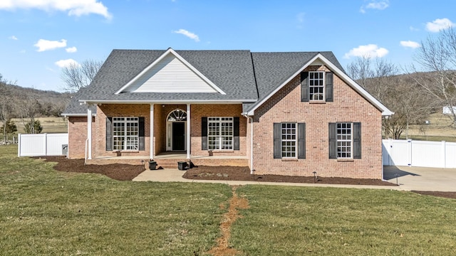 view of front of home featuring covered porch, brick siding, a front lawn, and a gate