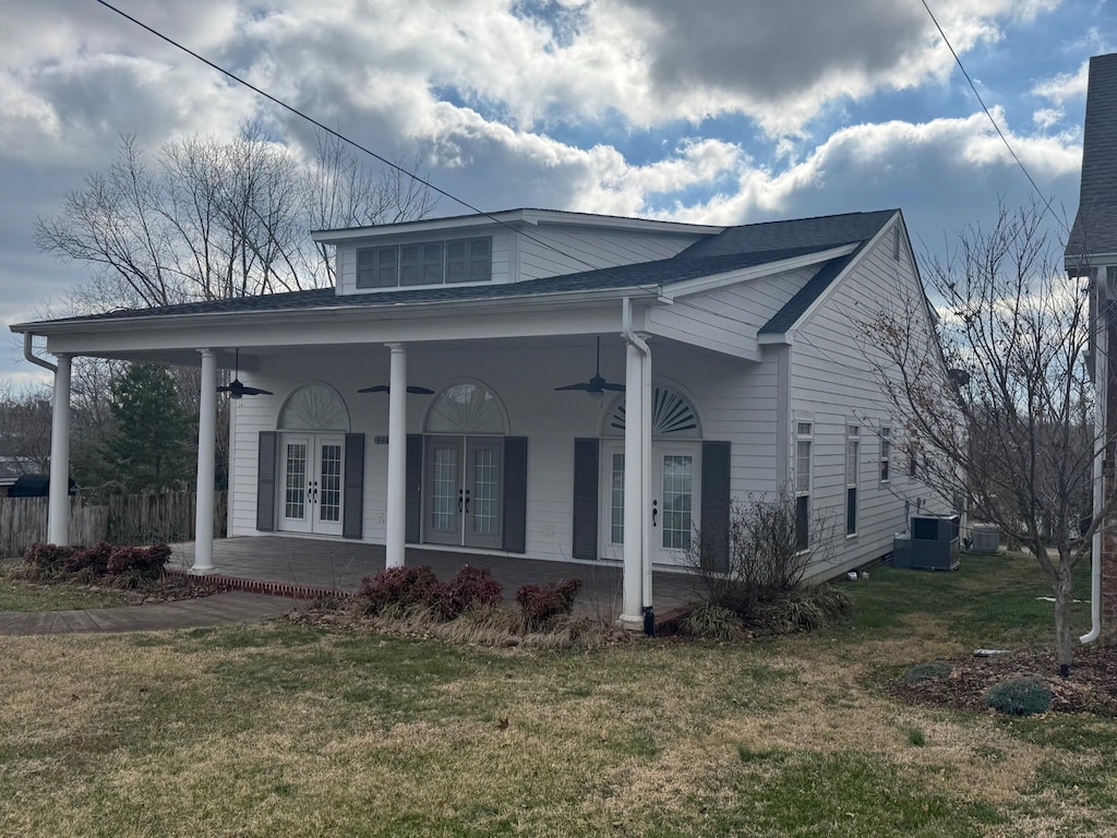 bungalow-style house with french doors, a porch, central AC unit, ceiling fan, and a front lawn