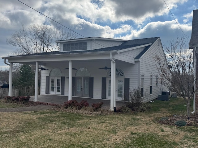 bungalow-style house with french doors, a porch, central AC unit, ceiling fan, and a front lawn