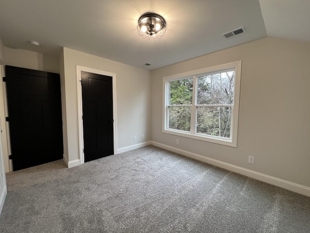 unfurnished bedroom with lofted ceiling and carpet floors