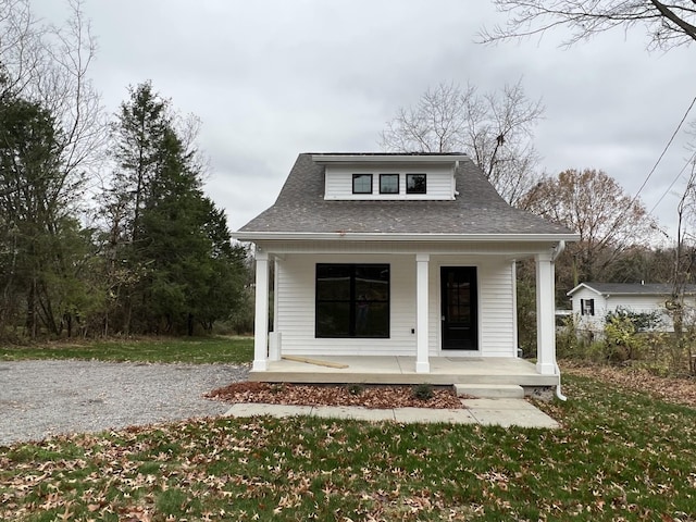 exterior space featuring covered porch and a lawn