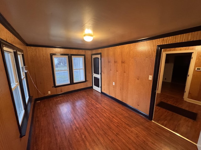 unfurnished bedroom with a closet, crown molding, and dark hardwood / wood-style floors