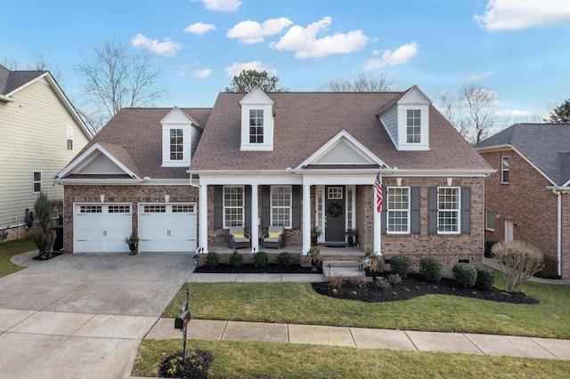 cape cod-style house featuring covered porch and a front lawn