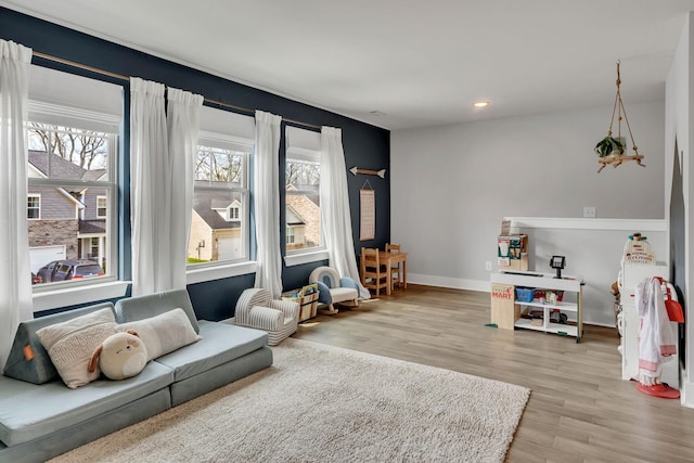 living room with a wealth of natural light and light hardwood / wood-style flooring